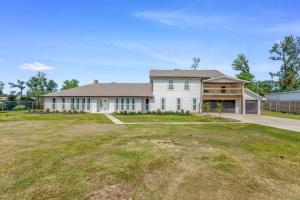 a large white house with a large yard at 5 Bedroom Home In Lake Charles in Lake Charles