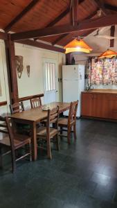 een keuken met een houten tafel en stoelen en een koelkast bij Hakuna Matata in Santa Rosa de Calamuchita