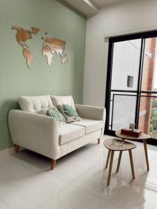 a living room with a couch and a world map on the wall at Acogedor departamento! in Luque