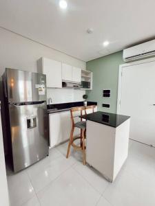 a kitchen with a stainless steel refrigerator and a table at Acogedor departamento! in Luque