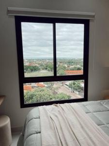 a large window in a bedroom with a bed at Acogedor departamento! in Luque