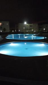 a group of three swimming pools lit up at night at Depto primer piso Quisco Norte in El Quisco