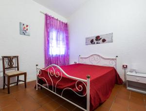 um quarto com uma cama com um cobertor vermelho e uma janela em Podere La Pinetina - Ct6 em Cecina