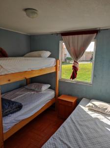 a bedroom with two bunk beds and a window at Depto primer piso Quisco Norte in El Quisco