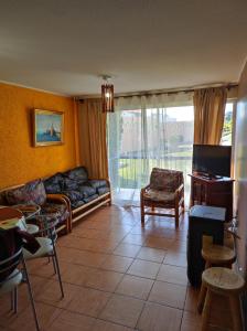 a living room with a couch and a tv at Depto primer piso Quisco Norte in El Quisco