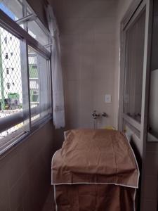 a hospital room with a bed and a window at Apartamento Na Praia Das Astúrias in Guarujá