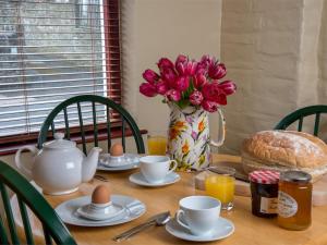 uma mesa com um vaso de flores e ovos cor-de-rosa em 1 Bed in Bwlch BN367 em Bwlch