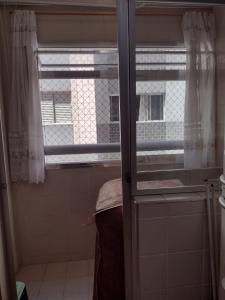 a bathroom with a window and a door with a window at Apartamento Na Praia Das Astúrias in Guarujá