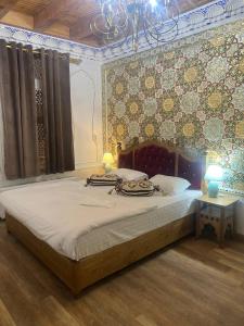 a bedroom with a large bed and a wall with tiles at Central Asia Hotel in Bukhara