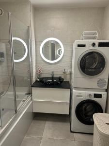 a bathroom with a washing machine and a washer at Appartement proche Paris et Disney land. in Rosny-sous-Bois