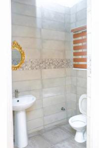 La salle de bains est pourvue d'un lavabo et de toilettes. dans l'établissement House 4 Guest House & Apartments, à Lagos