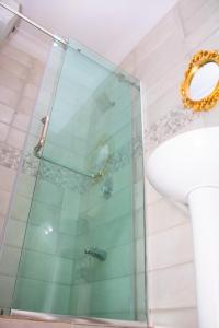 a glass shower in a bathroom with a sink at House 4 Guest House & Apartments in Lagos