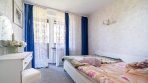 een slaapkamer met een bed en een raam met blauwe gordijnen bij Górska Róża in Szklarska Poręba