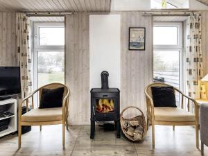 a living room with a stove and two chairs at 6 person holiday home in Karrebæksminde-By Traum in Karrebæksminde +39 photos