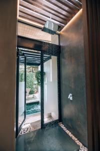 Villarreal的住宿－Epic Tamarindo Boutique Hotel，浴室设有通往庭院的玻璃门