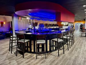 a bar with chairs and a blue counter in a room at Ramada by Wyndham Yuma in Yuma