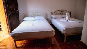 2 camas en una habitación pequeña con baño privado en Hotel Conquistador Veracruz en Veracruz