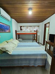 um quarto com uma cama e um tecto em madeira em Pousada Capricórnio em Guarda do Embaú