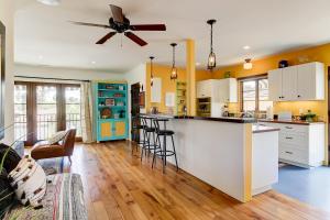 a kitchen with white cabinets and a ceiling fan at West Beach Villa 6 in Santa Barbara