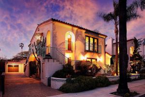 a white house with a palm tree in front of it at West Beach Villa 6 in Santa Barbara