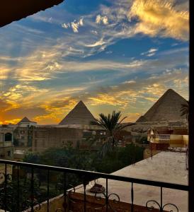 een uitzicht op de piramides van Giza bij zonsondergang bij Aoda pyramids in Caïro