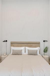 a bedroom with a large white bed with two lamps at Villa Castillo 2 in Santa Barbara