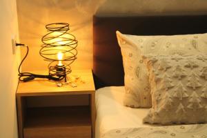 una lámpara en una mesita de noche junto a una cama en Kovac Inalux Apartmani, en Gornje Pale
