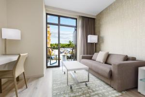 a living room with a couch and a table at AC Hotel by Marriott Naples 5th Avenue in Naples