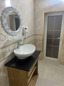 a bathroom with a sink and a mirror on the wall at Central Asia Hotel in Bukhara