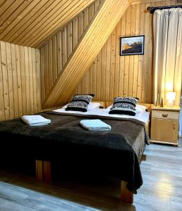 sypialnia z dużym łóżkiem w drewnianym pokoju w obiekcie Noclegi Sarenka w Murzasichlu