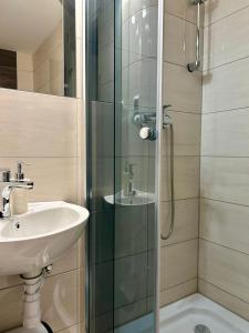 a bathroom with a glass shower and a sink at Noclegi Sarenka in Murzasichle