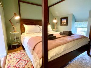 a bedroom with a large bed in a room at Tetbury Cottage 