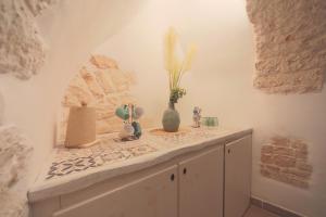 une chambre avec un comptoir et un vase sur lui dans l'établissement Trullo Artemis, à Alberobello