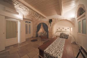 a bedroom with a bed and a table and chairs at Trullo Artemis in Alberobello