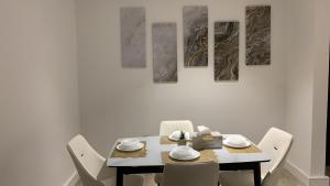 a dining room with a table and white chairs at Down Town Appartment w/King bed in Riyadh
