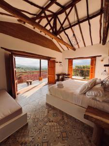 a bedroom with a large bed and a balcony at Casa Bocore in Barichara