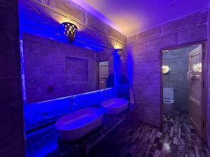 a bathroom with two toilets and a blue lighting at ACHERTOD NUBIAN HOTEL in Naj‘ al Maḩaţţah