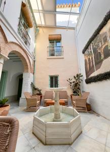 a courtyard with a fountain in the middle of a building at DS Palacio de la Luna in Córdoba