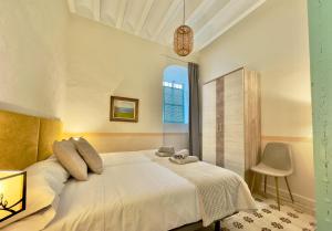 a bedroom with a large white bed and a window at DS Palacio de la Luna in Córdoba