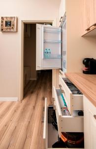 eine Küche mit einem offenen Kühlschrank und Holzböden in der Unterkunft Loris Apartaments 205 in Durrës