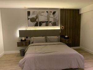 Down Town Appartment w/King bed في الرياض: غرفة نوم بسرير مع لوحة فوقها