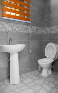 La salle de bains est pourvue de toilettes et d'un lavabo. dans l'établissement House 4 Guest House & Apartments, à Lagos