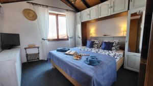 a bedroom with a bed with blue sheets and a television at Perlica in Vodice