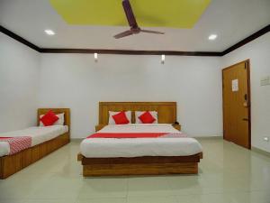 a bedroom with two beds and a ceiling fan at OYO Flagship Ananda Inn in Madurai