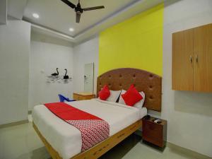 a bedroom with a bed with red and yellow walls at OYO Flagship Ananda Inn in Madurai