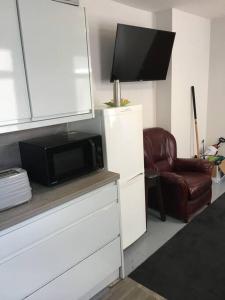 un salon avec un micro-ondes et une chaise dans l'établissement Budget room 10min Walk to Swansea Centre 1, à Swansea