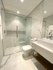 uma casa de banho com um chuveiro, um WC e um lavatório. em Quarto do Praia Brava Hotel em Florianópolis