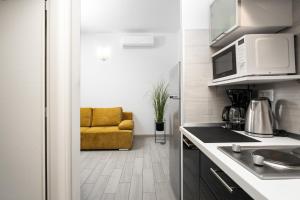 Una cocina con un sofá amarillo en una habitación. en Astrid 1 by Briskva, en Rabac