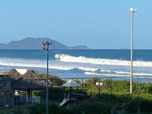 uma vista para o oceano com uma luz de rua e cadeiras em Quarto do Praia Brava Hotel em Florianópolis