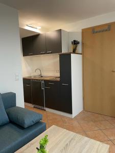 ein Wohnzimmer mit einem Sofa und einer Küche in der Unterkunft Gästehaus Maxi in Rust